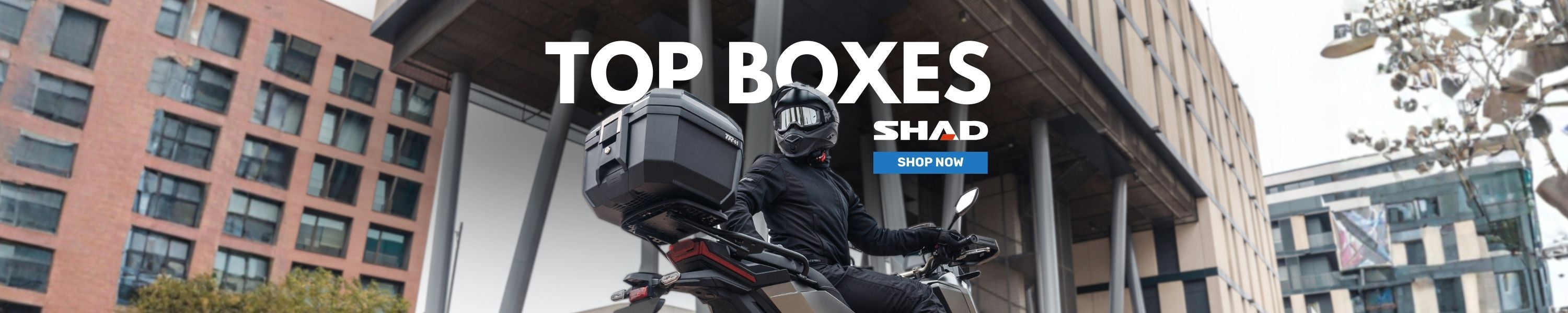 urban motorcyclist with SHAD motorcycle luggage top boxes 'shop now' banner 