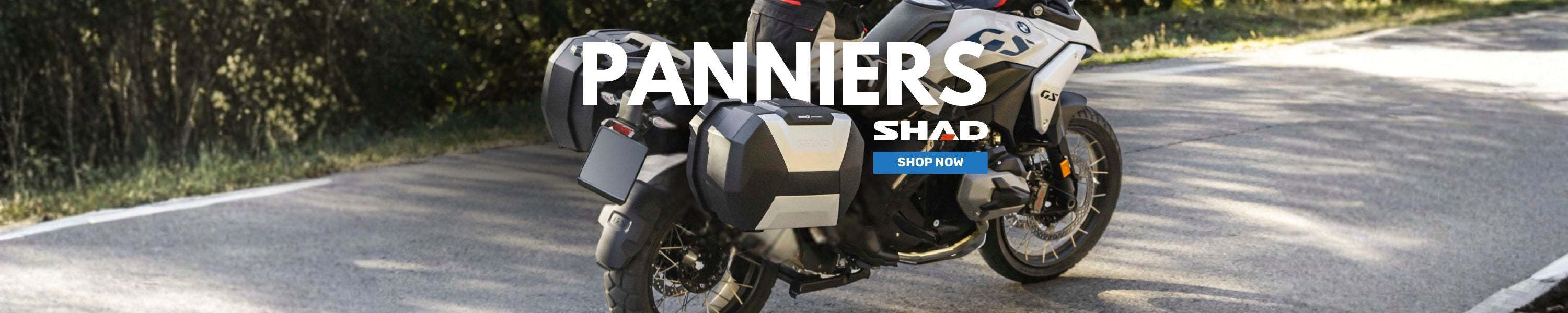 Motorcycle with panniers on a road, featuring 'Panniers' 'SHAD' logo 'shop now' promotional banner